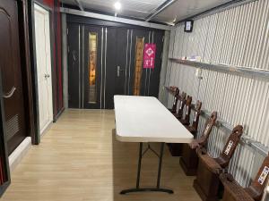 a table in a room with chairs and a door at Star & Moon GUEST HOUSE in Hengchun South Gate