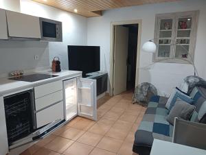 a kitchen and a living room with a couch and a tv at Cau d'en Magí - Apartament Casc Antic in Tarragona