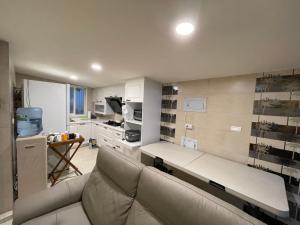 a living room with a couch and a kitchen at Star & Moon GUEST HOUSE in Hengchun