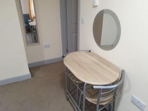 a table and a mirror in a room at Comfortable ground floor studio apartment. in Carlisle