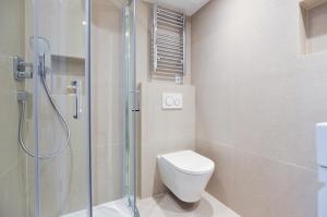 a bathroom with a toilet and a glass shower at New Cavendish Street Serviced Apartments by StayPrime in London