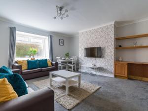 - un salon avec un canapé et une table dans l'établissement Chestnut House - Cosy 2 bedroom - Ashington, à Ashington