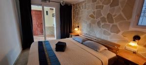 um quarto com uma cama com uma parede de pedra em Casa Rural Buenavista Pedralba em Pedralba