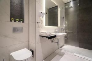 une salle de bain avec toilettes, lavabo et douche dans l'établissement Hotel Element, à Novi Sad