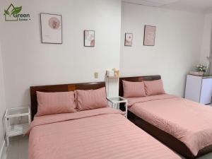 大叻的住宿－Vgreen Home，配有粉红色床单的客房内的两张床