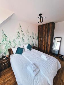 una camera da letto con un letto bianco con alberi di Natale sul muro di Cozy Forest Kopaonik a Kopaonik