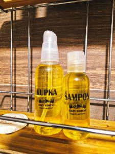two bottles of yellow oil sitting on a shelf at Cozy Forest Kopaonik in Kopaonik