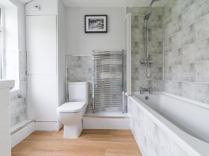 La salle de bains est pourvue de toilettes, d'une baignoire et d'une douche. dans l'établissement Hawthorn House - 2bedroom-Ashington Northumberland, à Ashington