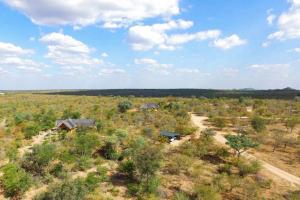 an overhead view of a field with houses and trees at Luxe GAME-LODGE bordering Kruger in Phalaborwa