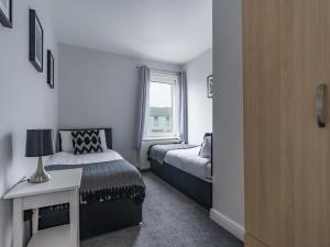 1 dormitorio con 2 camas y ventana en Hawthorn House - 2bedroom-Ashington Northumberland, en Ashington