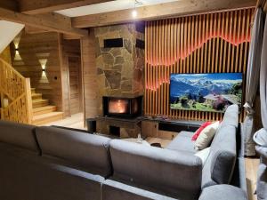 a living room with a couch and a television at Hillview Jasná Chalet in Demanovska Dolina