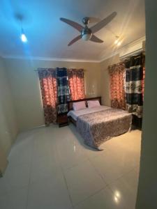 Schlafzimmer mit einem Bett und einem Deckenventilator in der Unterkunft OKF OBOUBA APARTMENT in Kumasi
