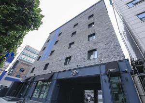 a large brick building with a store front at Sillim Dominique Hotel in Seoul