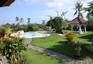 um jardim com uma piscina e um gazebo em Villa Bali Pondok Jepang em Lovina
