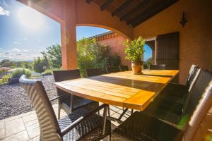 a wooden table and chairs on a patio at Les Villas de Perret in Joyeuse