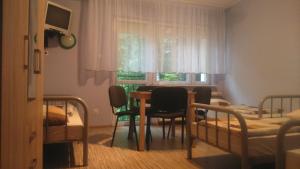 BOSiR Białogard في بياووغارد: غرفة صغيرة مع طاولة وكراسي وغرفة نوم