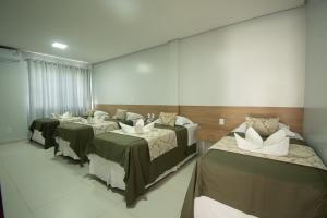 a room with three beds and a mirror at Hotel Araçás in Carolina