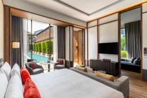 um quarto de hotel com uma cama grande e uma televisão em Villa Deva Resort & Hotel Bangkok em Bangkok