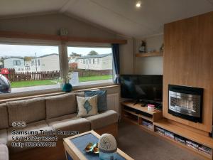 a living room with a couch and a flat screen tv at 205 Holiday Resort Unity Pet friendly pass includ in Brean