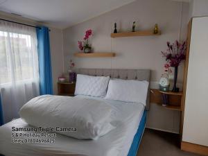 a bedroom with a bed with white sheets and a window at 205 Holiday Resort Unity Pet friendly pass includ in Brean