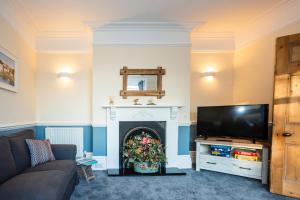 a living room with a fireplace and a television at SAUNTON NORBORO 4 Bedrooms in Braunton