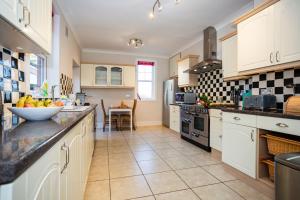 uma cozinha com armários brancos e uma tigela de fruta no balcão em SAUNTON NORBORO 4 Bedrooms em Braunton