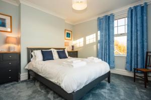 um quarto com uma cama com cortinas azuis e uma janela em SAUNTON NORBORO 4 Bedrooms em Braunton