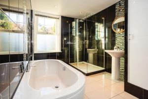 a bathroom with a tub and a shower and a sink at SAUNTON NORBORO 4 Bedrooms in Braunton +30 photos
