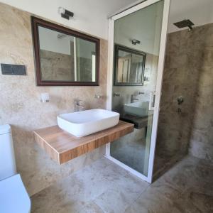 bagno con vasca, lavandino e specchio di Dhammika Beach Palace a Wadduwa