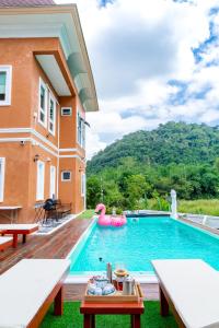 a swimming pool with a pink inflatable pool noodle in a house at Chateau de Luxi Khao Yai - ชาโตว์ เดอ ลูซี่ เขาใหญ่ in Mu Si