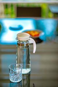 a bottle of water and a glass on a table at Chateau de Luxi Khao Yai - ชาโตว์ เดอ ลูซี่ เขาใหญ่ in Mu Si