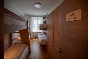 Pokój wieloosobowy z łóżkami piętrowymi i znakiem na ścianie w obiekcie Ostello Scudellate MONTE GENEROSO w mieście Scudellate