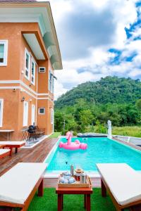 una piscina con una balsa inflable rosa en una casa en Chateau de Luxi Khao Yai - ชาโตว์ เดอ ลูซี่ เขาใหญ่, en Mu Si