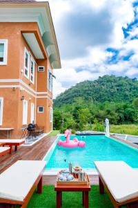 a pool with a pink inflatable raft in a house at Chateau de Luxi Khao Yai - ชาโตว์ เดอ ลูซี่ เขาใหญ่ in Mu Si