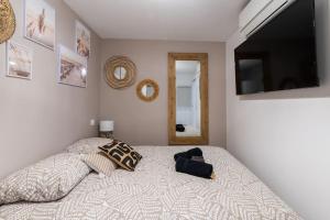 1 dormitorio con 1 cama y TV de pantalla plana en La Perle du Port * Terrasse * clim * mer à 5 min * chambre *, en Carnon-Plage