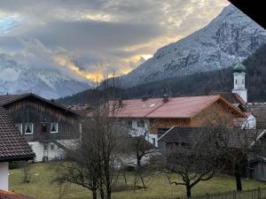 een dorp met een kerk en een berg bij Dachgeschosswohnung mit traumhaftem Zugspitzblick bei Garmisch in Farchant