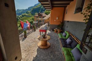 un patio al aire libre con sofás y una mesa con vistas en Ostello Scudellate MONTE GENEROSO en Scudellate