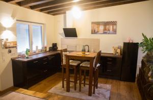 une cuisine avec une table et un bureau avec des chaises dans l'établissement Apartment Black der Sportschule Badura, à Leipzig