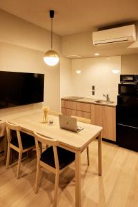 a kitchen with a wooden table with a laptop on it at Section L Hatchobori in Tokyo