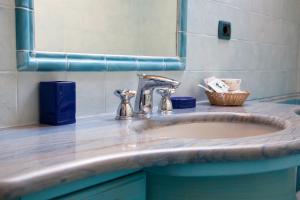 un lavandino del bagno con un rubinetto e uno specchio di The Sweet Garret ad Agerola Altre 13 foto
