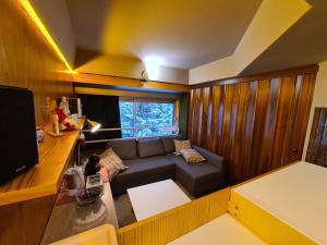 ein kleines Wohnzimmer mit Sofa und TV in der Unterkunft La casa di Ninis a Marilleva 1400 in Marilleva