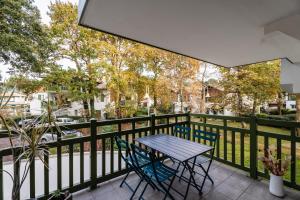 a patio with a table and chairs on a fence at Atlantic Selection - Proche du golf - Parking Wifi in Capbreton