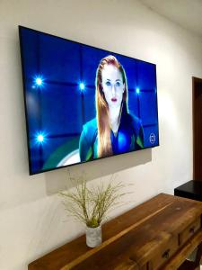 TV de pantalla plana colgada en la pared en TURISHOUSE SUITES en Salvador