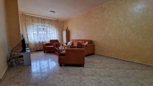 a living room with couches and chairs and a television at Apartment 24 in Pamporovo