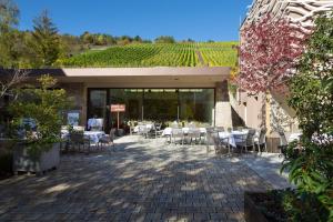 eine Terrasse mit Tischen und Stühlen in einem Gebäude mit Reben in der Unterkunft Rebgut in Lauda-Königshofen