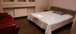 1 dormitorio con 1 cama y 1 sofá rojo en Grand appartement fonctionnel et calme sur lyon8 a 2 pas du metro, en Lyon