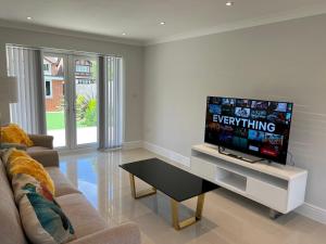 a living room with a tv and a couch at Pass the Keys Newly built house 4 mins from Twyford Centre in Reading