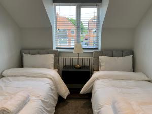 1 dormitorio con 2 camas y ventana en Pass the Keys Newly built house 4 mins from Twyford Centre en Reading