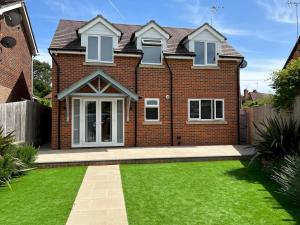 a house with a green lawn in front of it at Pass the Keys Newly built house 4 mins from Twyford Centre in Reading