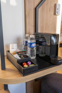 a tray with water bottles on a table at B&B HOTEL Bois d'Arcy Saint Quentin en Yvelines in Bois-dʼArcy